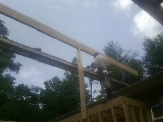 Carpenter setting a ridge beam over a new addition frame — Ice Dam Removal by Roofing Brothers in Woodacre
