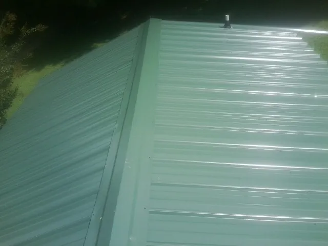 New green metal panels meeting at the ridge of a roof — Flat Roof Repair work by our crew in Woodacre