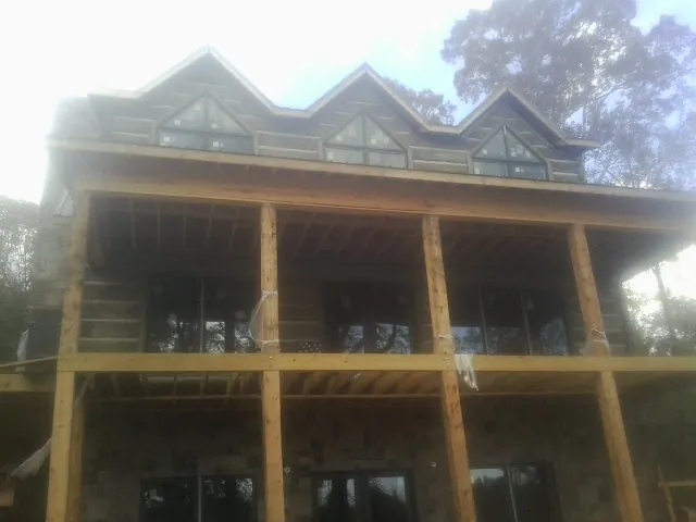 Dormers and porch framing on a large log home under construction — Roof Coating work by our crew in Woodacre